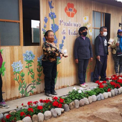 Leaders of the community garden in front of a building in the garden