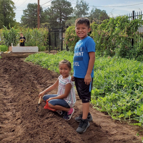 A photo of two children standing in the Native Health Traditional Garden 